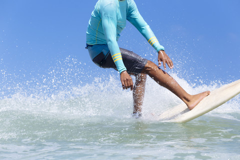 Indonesien, Bali, Beine eines Surfers auf einer Welle, lizenzfreies Stockfoto