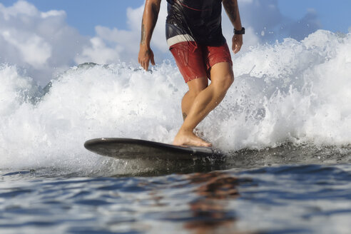 Indonesien, Bali, Beine eines Surfers auf einer Welle - KNTF00899