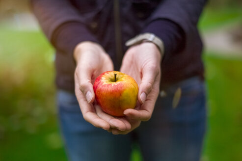 Nahaufnahme einer Frau, die einen Apfel hält - MMAF00134