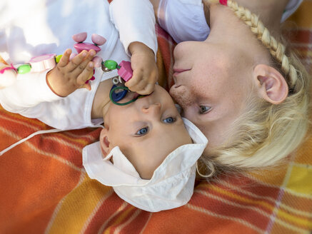 Mädchen spielt mit Baby auf Decke - LAF01890