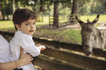 Portrait of toddler being held by his mother in a wildpark - MFF03955