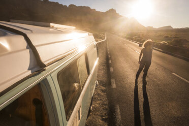 Spain, Tenerife, woman standing on country road at sunset - SIPF01759