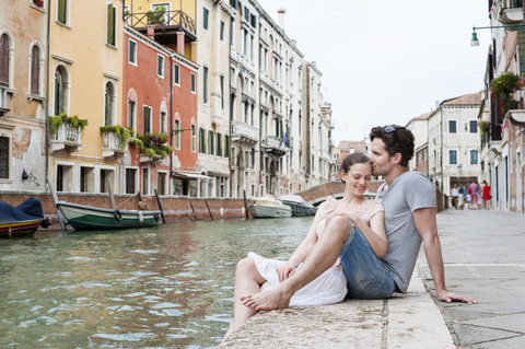 Italy, Venice, couple in love relaxing at canal stock photo