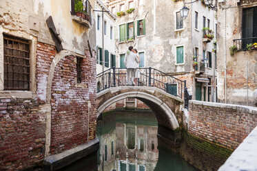 Italien, Venedig, Brautpaar auf kleiner Brücke stehend - DIGF02851