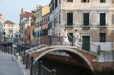 Italien, Venedig, Brautpaar läuft auf kleiner Brücke - DIGF02857