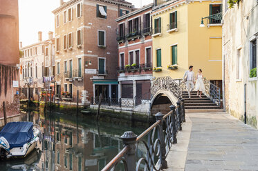 Italien, Venedig, Brautpaar geht auf kleiner Brücke - DIGF02859