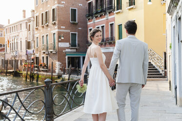 Italien, Venedig, glückliches Brautpaar geht Hand in Hand - DIGF02860