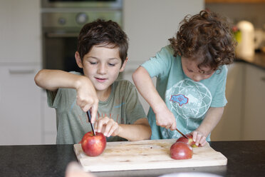 Two little brothers cutting apples in the kitchen - LBF01642