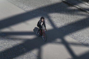 Erhöhte Ansicht eines lächelnden Mannes mit Sonnenbrille beim Fahrradfahren - SBOF00711