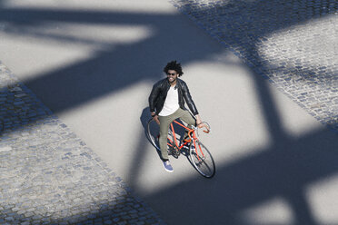 Erhöhte Ansicht eines lächelnden Mannes mit Sonnenbrille auf einem Fahrrad - SBOF00712