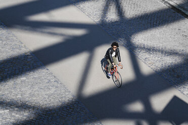Erhöhte Ansicht eines lächelnden Mannes mit Sonnenbrille beim Fahrradfahren - SBOF00713