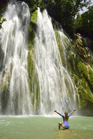 Dominikanische Republik, Samana, Frau bewundert riesigen Wasserfall, lizenzfreies Stockfoto