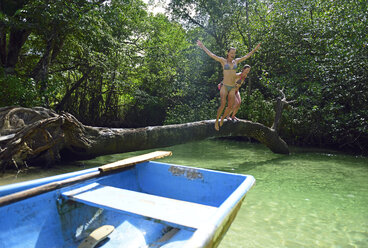Dominikanische Republik, Samana, zwei Frauen, die in einer Mangrovenlagune ins Wasser springen - ECPF00116
