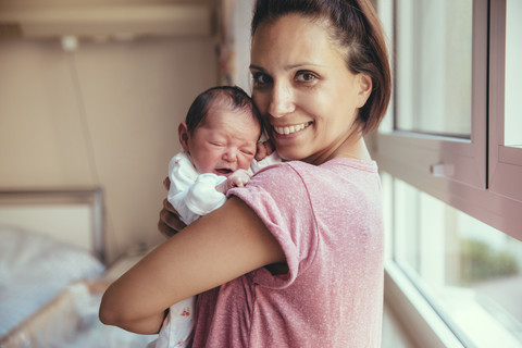 Portrait of happy mother holding her newborn baby in hospital stock photo