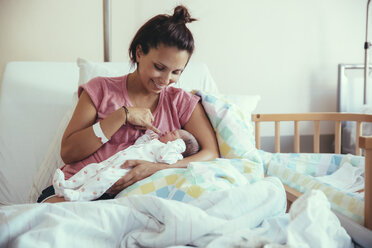 Happy mother with her newborn baby in hospital bed - MFF03979