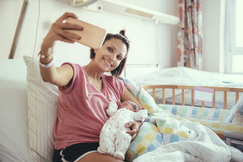 Mutter macht ein Selfie mit ihrem neugeborenen Baby im Krankenhausbett - MFF03980