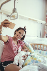Mutter macht ein Selfie mit ihrem neugeborenen Baby im Krankenhausbett - MFF03981
