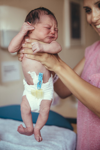 Newborn baby girl in hospital holding by mother's hands stock photo