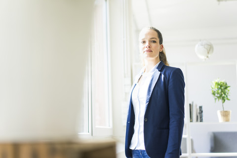 Porträt einer selbstbewussten Geschäftsfrau am Fenster, lizenzfreies Stockfoto