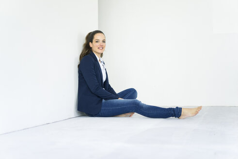 Porträt einer Geschäftsfrau auf dem Boden sitzend - JOSF01782
