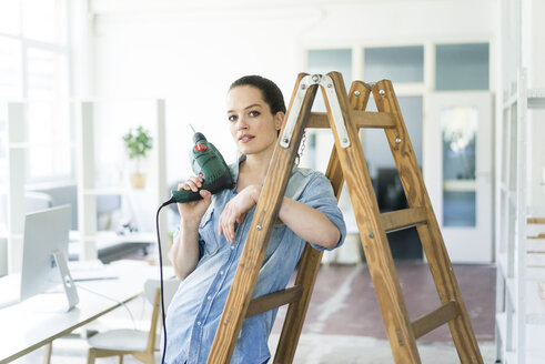 Porträt einer Frau an einer Leiter mit einer elektrischen Bohrmaschine - JOSF01799