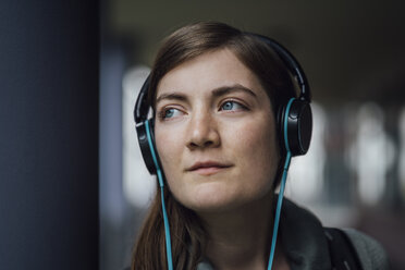 Porträt einer träumenden jungen Frau, die mit Kopfhörern Musik hört - JSCF00005