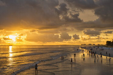 USA, Florida, Fort Myers, Silhouetten von Fort Myers Beach und Touristen mit einer riesigen Regenwolke darüber bei Sonnenuntergang - SHF01965