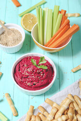 Bowl of beetroot hummus, sesame, carrot and celery crudites and breadsticks - RTBF01002