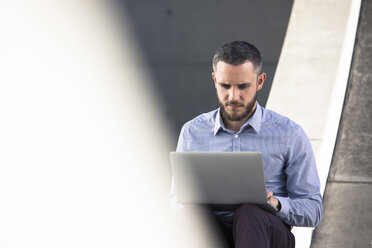 Businessman using laptop outdoors - FKF02531