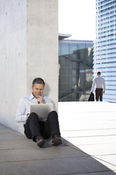 Businessman using laptop outdoors - FKF02532