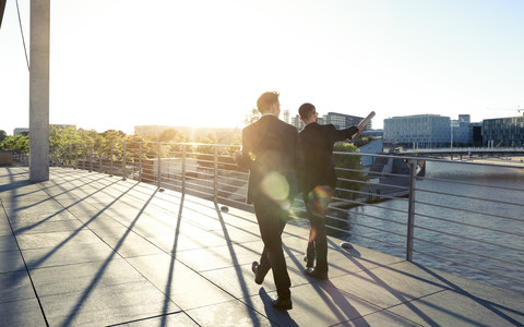 Zwei Geschäftsleute gehen auf einer Brücke in der Stadt, lizenzfreies Stockfoto