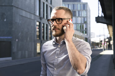 Geschäftsmann am Handy in der Stadt - FKF02559