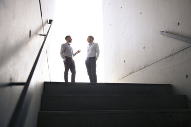 Two businessmen talking in a passageway - FKF02578