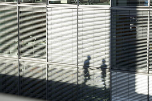 Schatten von zwei Geschäftsleuten auf einer Markise - FKF02584