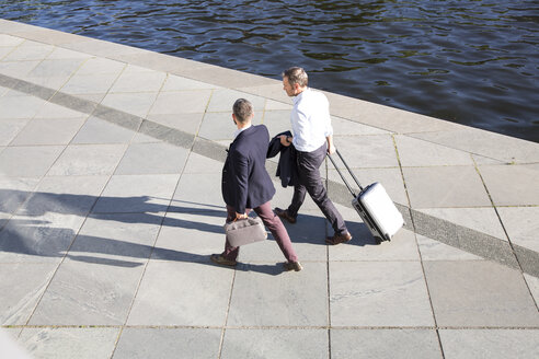 Two businessmen walking and talking at the riverbank - FKF02585