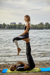 Young man and woman practicing Acro Yoga - ZEDF00888