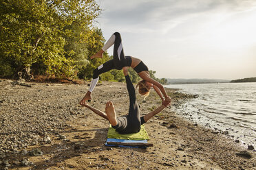 Junger Mann und Frau üben Acro Yoga - ZEDF00889