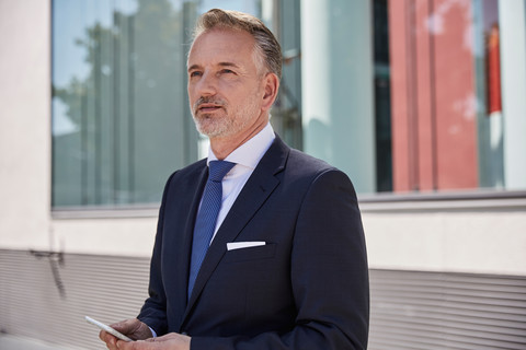 Porträt eines Geschäftsmannes mit Mobiltelefon, lizenzfreies Stockfoto