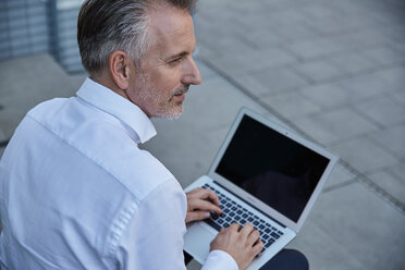 Porträt eines Geschäftsmannes mit Laptop im Freien - SUF00293
