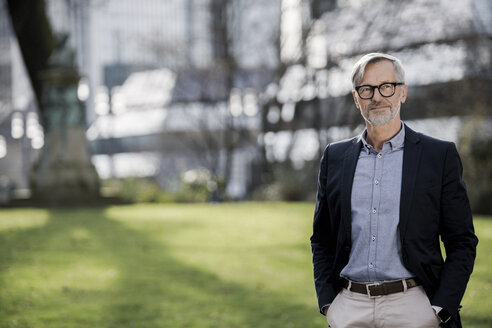 Grey-haired businessman in city park - SBOF00746