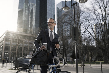 Grauhaariger Geschäftsmann mit Fahrrad und Kaffee zum Mitnehmen in der Stadt - SBOF00785