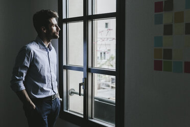 Young businessman looking out of window - GIOF03278