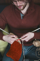 Young man knitting a scarf, partial view - RTBF01005