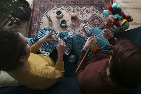 Young couple knitting and crocheting in living room - RTBF01012