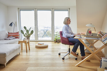 Reife Frau zu Hause mit Laptop am Schreibtisch - RBF06027