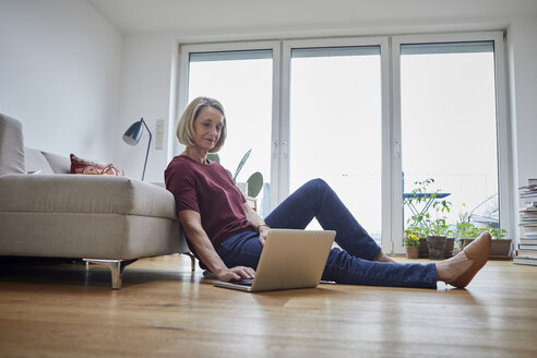 Reife Frau zu Hause mit Laptop auf dem Boden - RBF06035