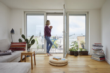 Reife Frau zu Hause mit Blick aus dem Balkonfenster - RBF06043