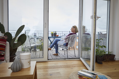 Reife Frau zu Hause auf dem Balkon sitzend - RBF06046