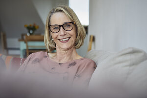 Portrait of smiling mature woman at home on the sofa - RBF06064
