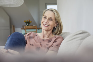 Portrait of smiling mature woman at home on the sofa - RBF06065